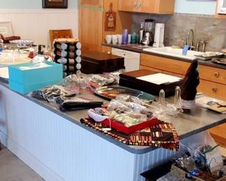 Lots of Kitchen items in the second Kitchen in the basement. Sets of Stainless Flatware, Tupperware, Tiffany Champagne glasses in box and more