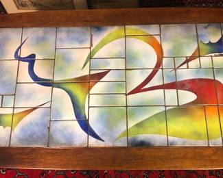 Enamel coffee table top signed lower right. Enamel has some chipping and the coffee table wood frame has a dog bites/wear