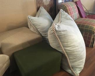 A couple of cube ottomans, 2 giant down-filled floor pillows covered in suede cloth. Slipper chair covered in pastel plaid fabric.