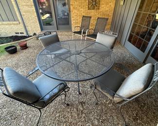 Round wrought iron table with 5 matching chairs (4 with cushions)