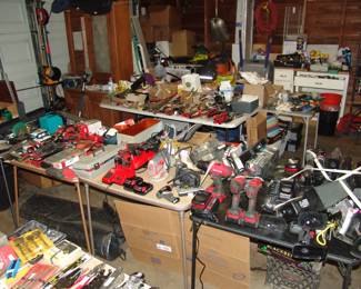 Garage packed with tools and construction products including cabinets, vanities, sinks, shelves, etc
