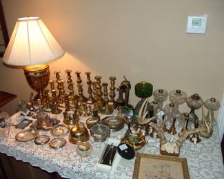 Large collection of antique brass candlesticks and oil lamps