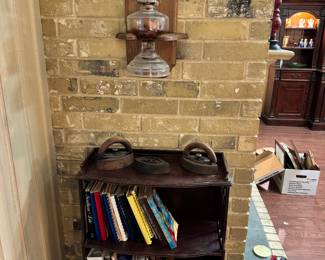 Wall hanging oil lamp. Cook books are always a favorite. Small wooden book shelf.