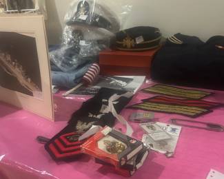 Military Table with hats, pics, patches, clothing, uniforms. Metals available at cashier 