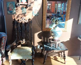 High back carved wood chair, large mirror, Mercury glass urn, marble top table and Retablos on tin