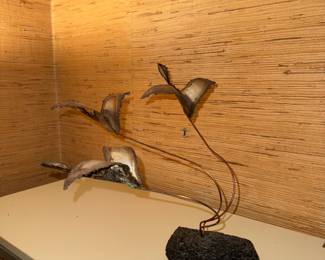 MCM flying geese brass sculpture on a lava rock.