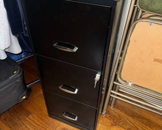 Small three drawer file cabinet with its key.