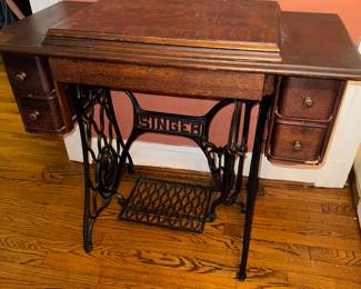 Antique Singer sewing machine in cabinet.