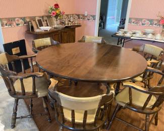 This is a beautiful vintage round table with 2 leaves. Has 6 captains chairs.