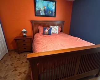Mission style queen bed with nightstand and stained glass lamp