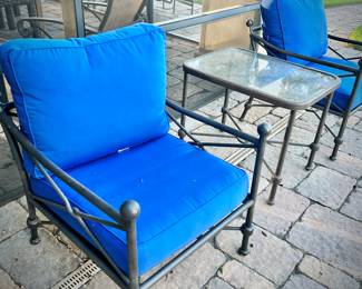 Four black metal outdoor chairs - two have solid blue upper cushions, and two have blue & white striped upper cushions. Three matching metal tables - one circular, one square, and one rectangular.