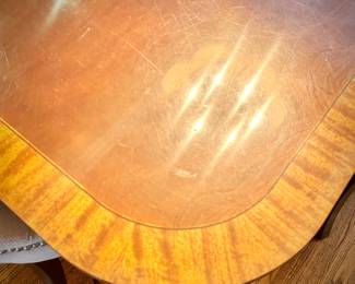 Mahogany dining table with two leaves (one shown).