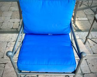 Four black metal outdoor chairs - two have solid blue upper cushions, and two have blue & white striped upper cushions.