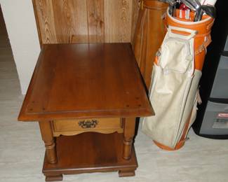 End table and a couple of sets of golf clubs, complete with bag