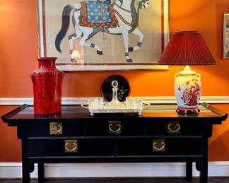 $850; original, hand-painted horse on fabric in gold frame; 51.5x37. SOLD—orange glazed large ceramic vase; 19.5h. $1500; Century brand 5-drawer pagoda style buffet with black finish and brass hardware; 72x18x31. $56; lacquerware hibiscus tray with red trim and floral accent; 12”d. $28; set of 4 rocks glasses. $60; glass decanter. $68; silver plated footed tray. $250; ceramic palace jar lamp with peacock accents; 20x28