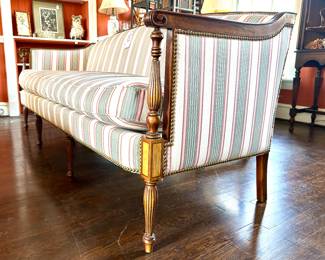 $500; striped, custom-upholstered couch with single seat cushion, detailed carved wooded legs, and nail head trim by Lammerts; 79x28x33
