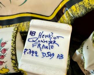 $280; set of 14 hand-painted HenRiot Quimper ceramic set including tray, vase and 12 napkin rings with botanical accents. Close up of artist mark.