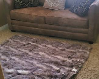 Sleeper sofa, pillows (priced separately), faux fur rug