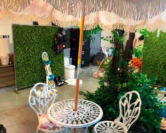 There are two iron table and chair set with two beach umbrellas