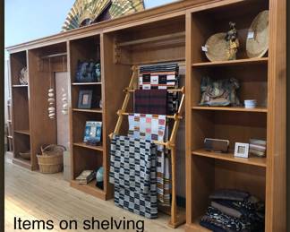 View of custom maple shelving unit (locally made by a carpenter) from the store it was originally in. Modular, breaks down into three bookcases with adjustable shelving and two floating shelves to hang clothing or textiles.
