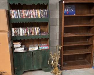 Bookcases and DVD Collection
Two wooden bookcases—one with a rustic green finish and the other in a classic brown tone—filled with a selection of DVDs, books, and games. Ideal for organizing your entertainment or library.