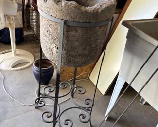 Rustic Stone Basin on Metal Stand
A rustic stone basin mounted on an elegant wrought iron stand. A perfect piece for garden or home decoration with a natural, earthy aesthetic.