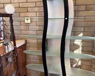 Curved Glass Display Shelf
A modern, curved glass and metal shelving unit. Its sleek and artistic design makes it an ideal statement piece for showcasing collectibles or books.