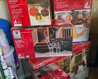 Outdoor holiday decor: string lights, wire reindeer, dog, gift boxes, wreath