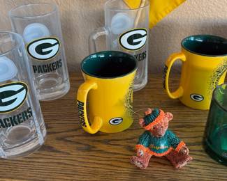 Green Bay Packers NFL memorabilia: beer steins, coffee mugs, tire cover, gnome, cutting board