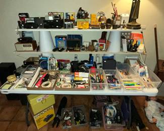 Table full of home office & lots of cameras and supplies