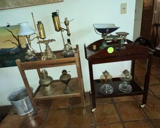 A pair of rolling carts with antique oil lamps & more