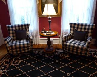 Pair of black & white wing chairs, table lamp, area rug, bookcase, framed decorative art