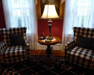 Pair of black & white wing chairs, table lamp, area rug, bookcase, framed decorative art