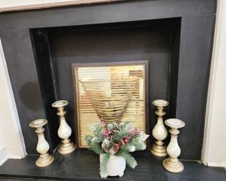 Unique candle holder framed with golden metal straps and a mirrored backdrop. 