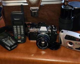 2 Olympus OM10 cameras, 2 lenses, 2 cases. Vintage cellphone.