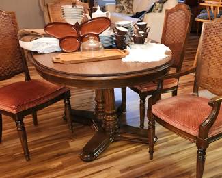 Vintage Ethan Allen Dining Table, 8 cane back chairs, 3 leaves & pads.
