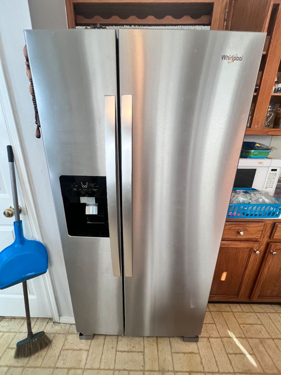 Whirlpool side by side stainless steel fridge with ice and water dispenser. Less than 6 months old. 