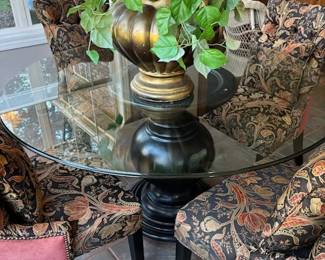 Round glass top table with black base and4 upholstered chairs