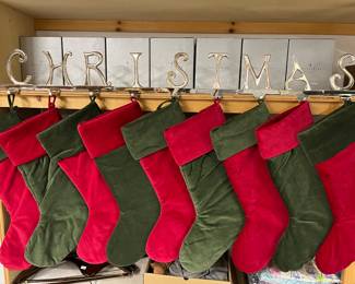 Nine Pottery Barn letter stocking holders (“Christmas”), with stockings.
