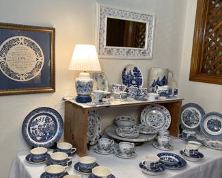 On the left side of the table is a small collection of vintage Blue Willow.  In the center is a 20-piece collection of vintage Blue Nordic Onion by Johnson Brothers.  Currier and Ives vintage pieces are on the right side of the table.