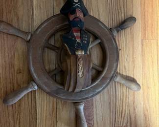 carved pirate on a ships wheel
