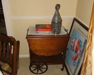 What we have here is an outstand cart, that is a real multitasker, which means it can serve food, or look great as a display piece. But we think that it would certainly make an outstanding bar cart. Oh, yeah and that sailboat print, and punched lamp on top of the magnificent barcart