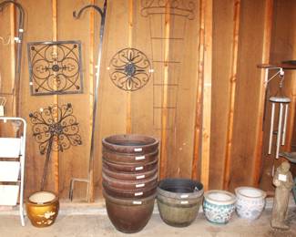 Variety of garden items, large resin flower pots, decorative metal wall hangings, concrete St. Christopher statue, metal and concrete bird baths and chimes.