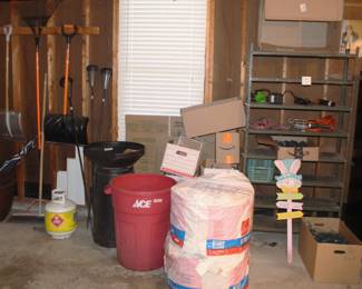 Shovels, gardening, 2 rolls fiberglass insulation, metal shelf.