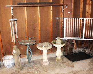 Variety of garden items, concrete St. Christopher statue, metal and concrete bird baths, chimes, large dog crate and child/dog gate.