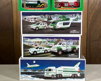 (5pc) [nib] Hess Trucks | Including a toy truck and race car, a space shuttle with satellite, a helicopter and rescue, firetruck, and miniature Hess first truck.
