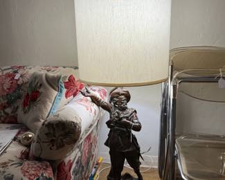 It seems to be a Musketeer supporting the lamp.  This is not very common, for sure.