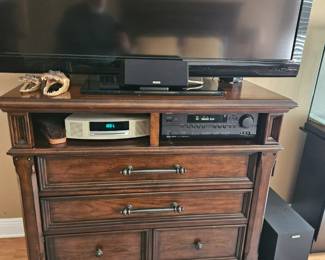 Solid wood entertainment center with television and surround sound.