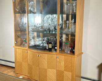 CONTEMPORARY ITALIAN HUTCH | Contemporary Italian China cabinet with curved breakfront, geometric blonde wood veneer, and 2 glass shelves over 4-door cabinet with light on top. - h. 82 x l. 72 x d. 19 in