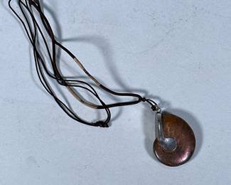 STERLING & FOSSILIZED AMMONITE PENDANT | Sterling silver and fossilized ammonite pendant on corded necklace, pendant marked "925" approx. 2 x 1.5 in. - l. 26 in (necklace)
